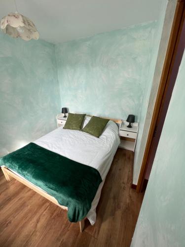 a small bed in a room with two night stands at Les Mouettes Blessées in Le Crotoy