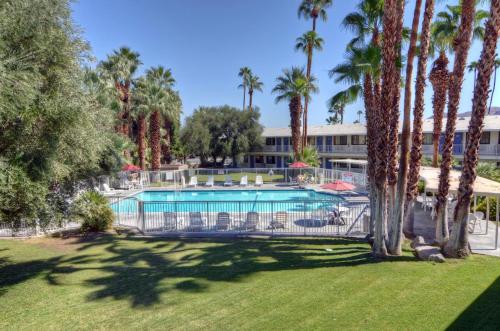 a resort with a swimming pool and palm trees at Motel 6-Palm Springs, CA - East - Palm Canyon in Palm Springs
