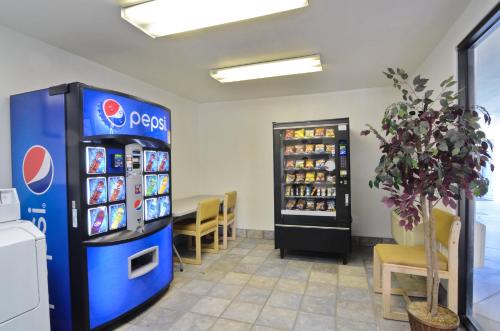 a room with a television, a refrigerator, and a table at Motel 6-Palm Springs, CA - East - Palm Canyon in Palm Springs