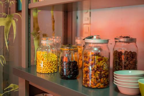 ブリーヴ・ラ・ガイヤルドにあるLogis Hotel Noemys Brive - Restaurant Le Teinchurierのさまざまな種類の食品が入った瓶が並んだ棚