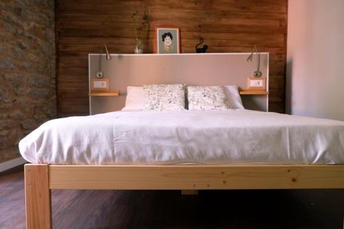 sypialnia z dużym białym łóżkiem i drewnianymi ścianami w obiekcie A casa da Penela w mieście Sas de Penelas