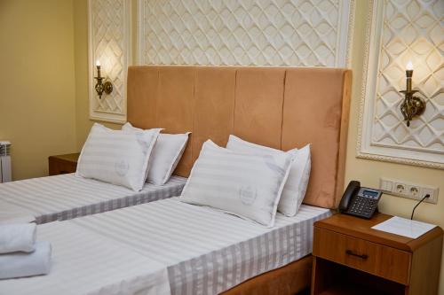 a hotel room with two beds and a telephone at Sangzor Boutique Hotel in Samarkand