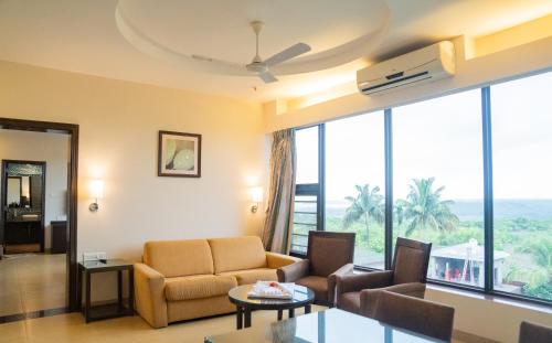 a living room with a couch and a table at Greenleaf The Resort & Spa, Ganpatipule in Ganpatipule