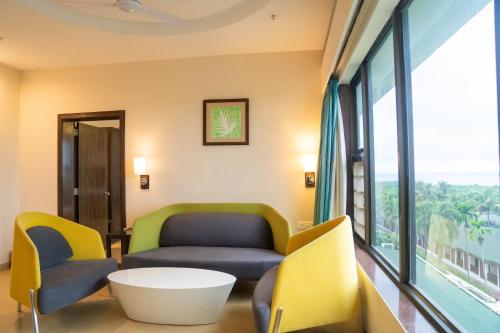 a waiting room with chairs and a couch and a table at Greenleaf The Resort & Spa, Ganpatipule in Ganpatipule