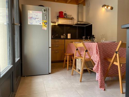 a kitchen with a table and a refrigerator at Le grand bleu in Bordes-de-Rivière
