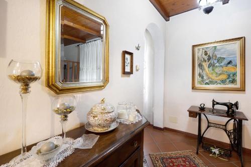 a room with a mirror and wine glasses on a dresser at Agriturismo U' Spigu in Garlenda