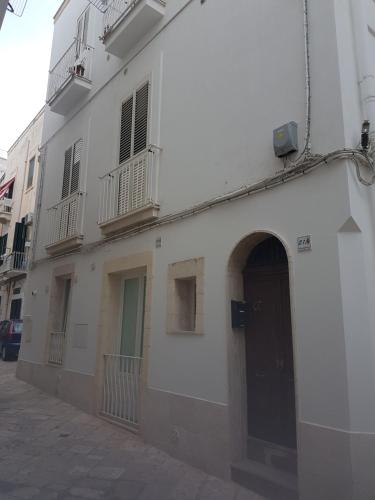 a white building with a door on a street at I ciclamini in Monopoli