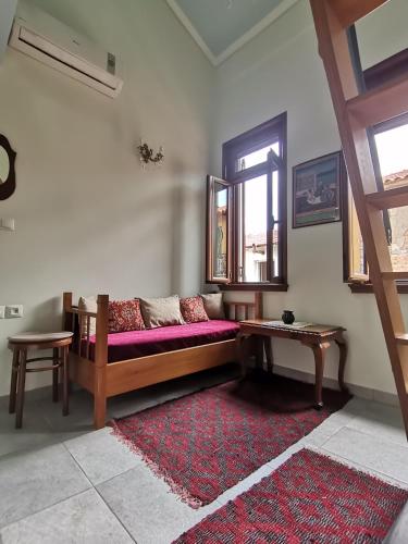 uma sala de estar com um sofá e um tapete vermelho em Ξενώνας Λήδα em Andrítsaina