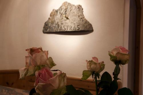 a sign on a wall next to some flowers at Hotel Astras in Scuol