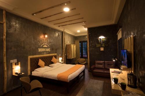a bedroom with a bed and a couch and a television at The HighGarden in Coonoor