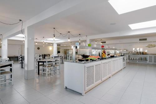 un restaurant avec un comptoir, des tables et des chaises dans l'établissement AluaSun Lago Park, à Cala'n Bosch