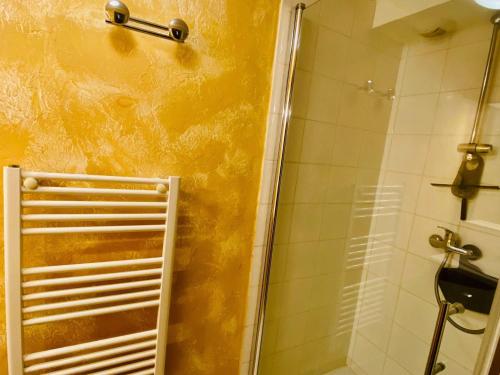 a bathroom with a shower with a yellow wall at Studio Montgenèvre, 1 pièce, 4 personnes - FR-1-445-142 in Montgenèvre