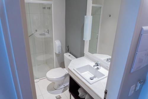 a bathroom with a toilet and a sink and a shower at Quality Faria Lima in Sao Paulo
