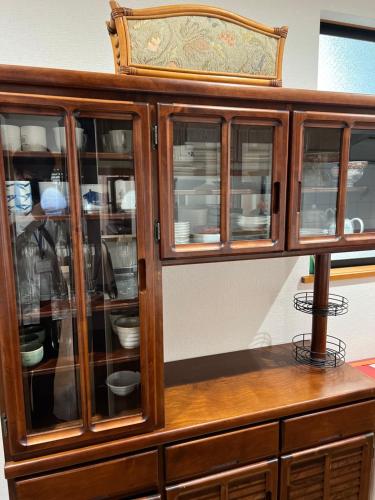 a wooden cabinet with glass doors at japan house shinkoiwa guest house in Tokyo