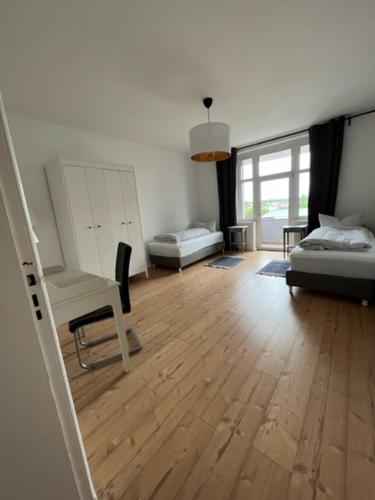 a living room with a couch and a chair and a wooden floor at Gästewohnung Eberswalde in Eberswalde