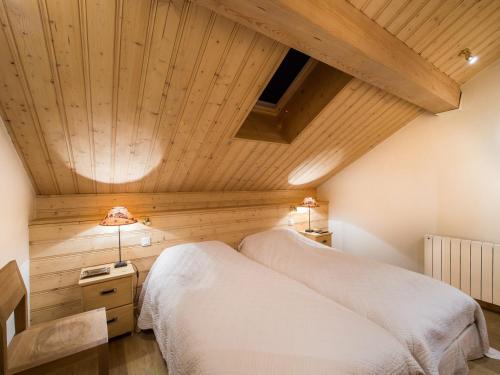 two beds in a room with a wooden ceiling at Appartement Méribel, 4 pièces, 6 personnes - FR-1-565-47 in Les Allues