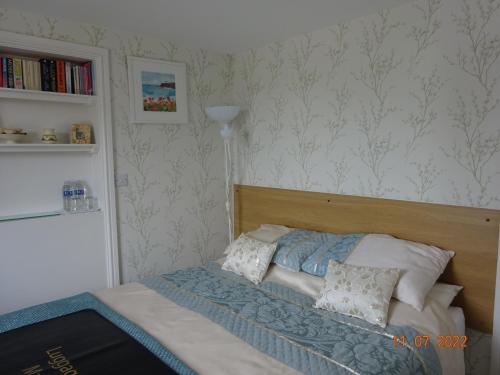 Un dormitorio con una cama con cabecero de madera. en Sterling Bed & Breakfast, en Llandudno