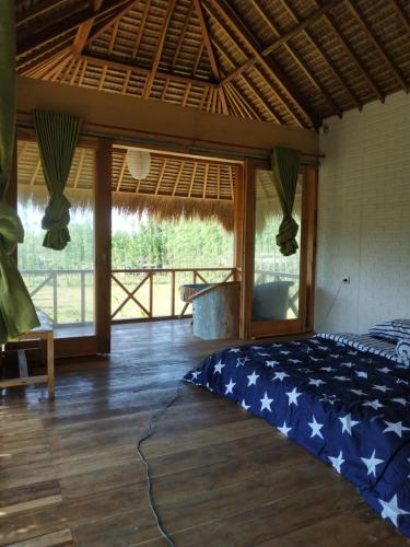 Zimmer mit einem Bett mit einer Tagesdecke mit amerikanischer Flagge in der Unterkunft Bebaleq Bangko Bangko in Labuhanpoh