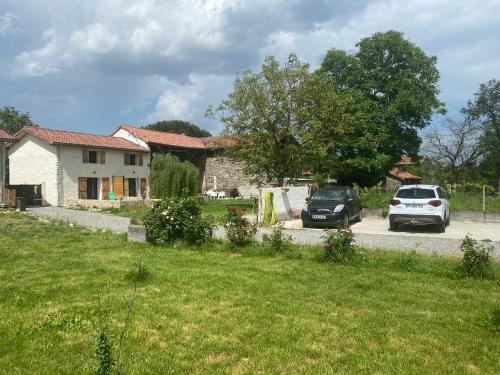 two cars parked in front of a house at Le grand bleu in Bordes-de-Rivière