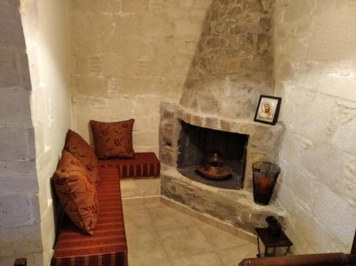a living room with a stone fireplace with a couch at Villa Kalliopi in Lápithos