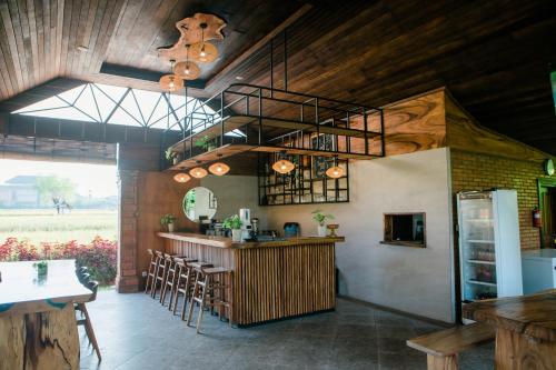 a kitchen with a bar in a room with wooden ceilings at Adil Villa & Resort in Ubud