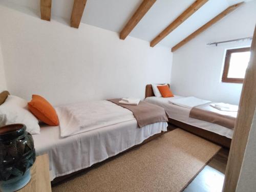 2 łóżka w pokoju z białymi ścianami i oknem w obiekcie Green Paradise Kolašin w mieście Kolašin