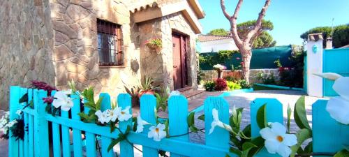 ein blauer Zaun vor einem Haus mit Blumen in der Unterkunft Villa Zahara in Chiclana de la Frontera