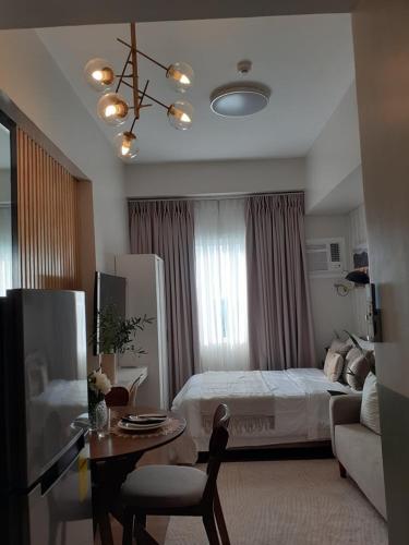 a bedroom with a bed and a table and a couch at Lifestyle at The Loop Towers Condotel in Cagayan de Oro