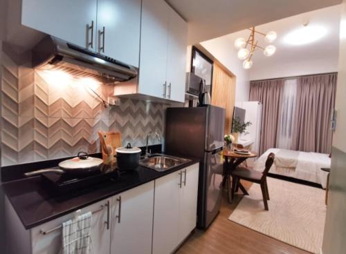 uma cozinha com um lavatório e um frigorífico num quarto em Lifestyle at The Loop Towers Condotel em Cagayan de Oro