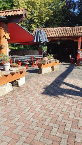 a patio with umbrellas and tables with plants at Landhotel Brauner Hirsch in Kammerforst