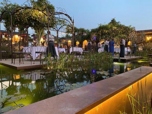 a restaurant with a pond with tables and people standing around at La Boheme Chambres in Lazise