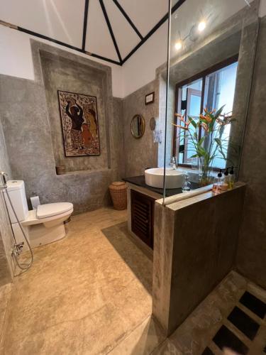 a bathroom with a sink and a toilet at Rosyth Estate House in Pinnawala