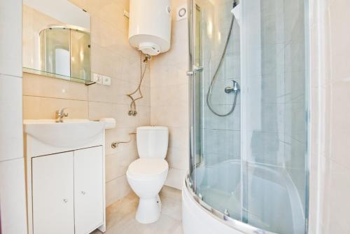 a bathroom with a shower and a toilet and a sink at Ośrodek Wypoczynkowy Jantar in Krynica Morska