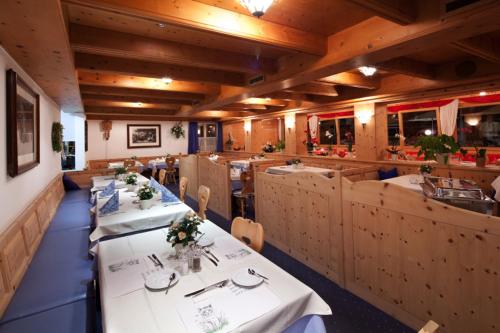 a dining room with tables and chairs in a restaurant at Hotel Astras in Scuol
