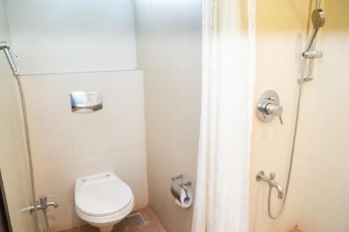 a small bathroom with a toilet and a shower at Greenleaf The Resort & Spa, Ganpatipule in Ganpatipule