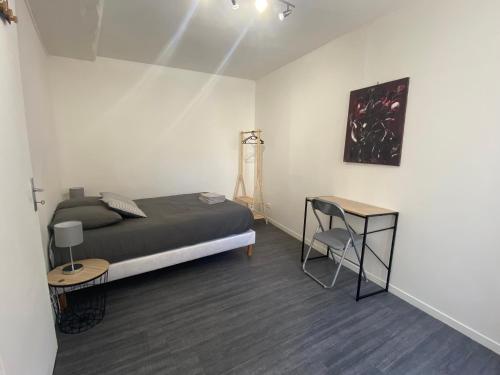 Un dormitorio con una cama y una mesa. en L'appartement ZEN LOC 2, en Bray-sur-Seine