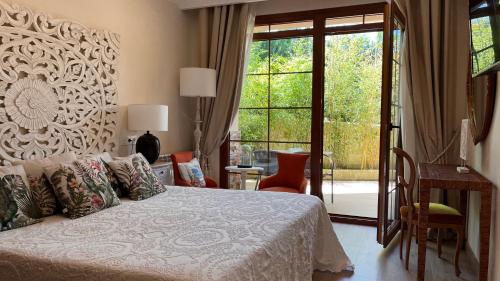 a bedroom with a bed and a sliding glass door at Hotel Rural Playa de Aguilar in Muros de Nalón