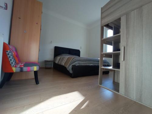 a bedroom with a bed and a chair and a mirror at LE VIEUX MOULIN in Aureilhan