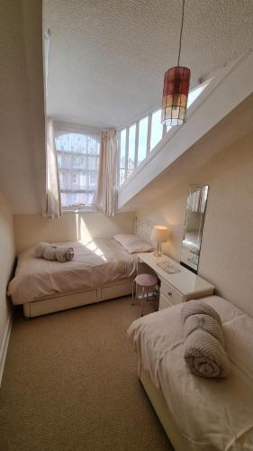 a bedroom with two beds and a window at Cruden Villa - Second Floor Apartment in Scarborough