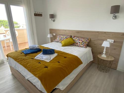 um quarto com uma cama grande e uma cabeceira em madeira em Stil Port Mar Anna em L'Escala