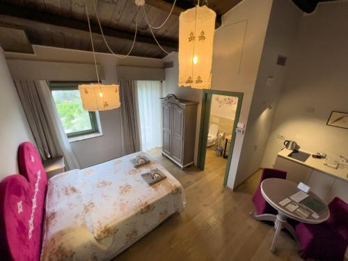 a bedroom with a bed and a table and chairs at Relais Cocci Grifoni - Panoramic Wine Resort in Offida