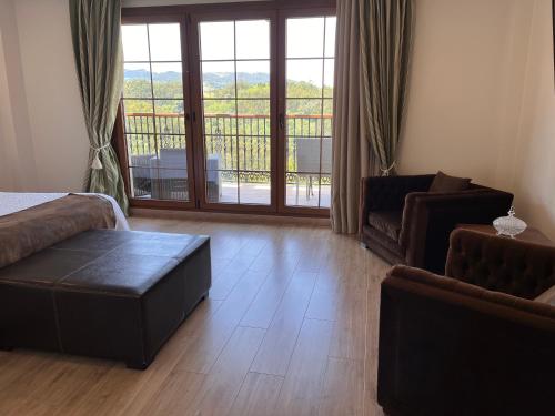 a living room with a couch and a table and a balcony at Hotel Rural Playa de Aguilar in Muros de Nalón