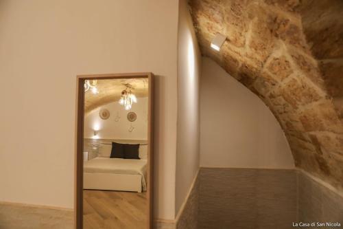a mirror in a room with a couch and an archway at La casa di San Nicola in Bari