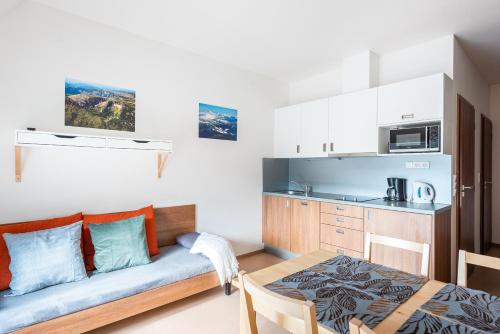 a living room with a couch and a kitchen at Apartmány Rokytka Snowhouse in Rokytnice nad Jizerou