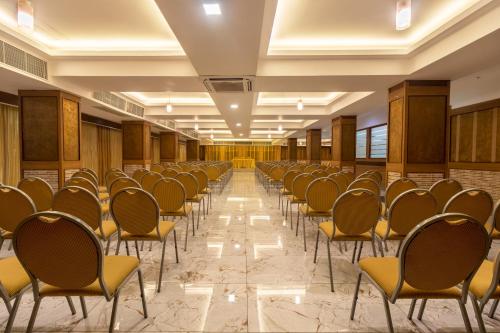 a row of chairs lined up in a hall at Zip By Spree Hotels Mangala Towers Thrissur in Trichūr
