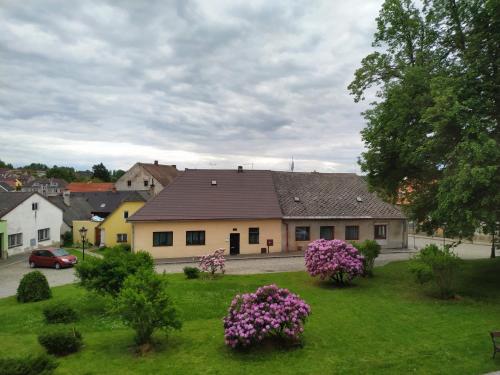 a house with purple flowers in a green yard at Apartmán Počátky in Počátky