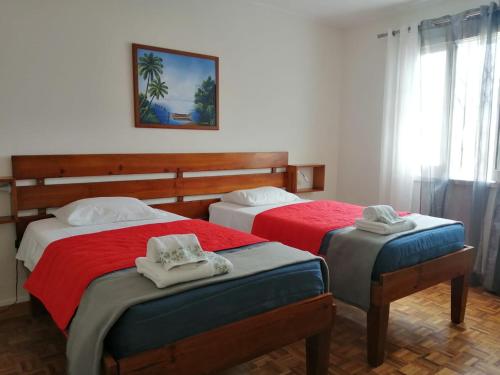 a bedroom with two beds with towels on them at House of Roses in Ponta Delgada