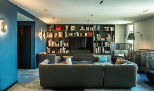 a living room with a couch and a book shelf at Crowne Plaza - Nice - Grand Arenas by IHG in Nice