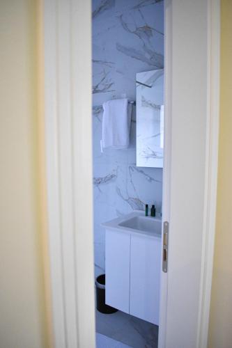 a bathroom with a sink and a marble wall at DelMar Apartments in Golem