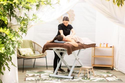 a woman getting a massage in a bed at Logis Hôtel Domaine du Moulin Cavier - Restaurants & Spa in Avrillé